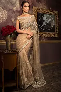Banarsi jamawar blouse contains embroidered border on the neckline. Net saree contains flourishing embellishments all around the edges. Stones spray scattered all over the saree. Large motif implemented at the centre of saree.