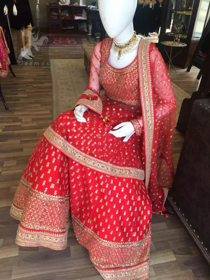 Simple but elegant deep red bridal blouse having dull golden and light antique embellishment. Appliqued with bright red fabric. Red lehengha having large borders of hand embellishment and small motifs spray above the hemline. Same border as on lehengha has been implemented on dupatta with motifs spray all over it.