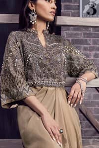 Fawn brown silky maxi has embellished bodice and sleeves. Bodice and sleeves have been embellished with dark gray embellishment and ivory pearls.