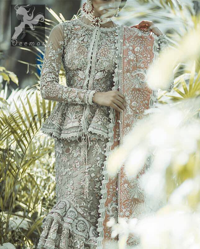 Fawn short length peplum made with net having embellished belt on waist. Large embellished border having peach appliqued on dupatta. Dupatta is adorned with rectangular shapes of embellishment small motifs all over it. Fitted lehenga having extra layer above the knees.