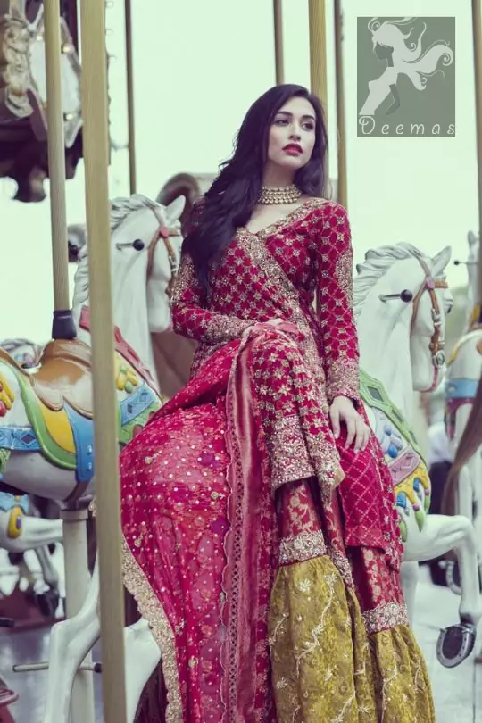 Cardinal pink self embroidered chiffon angrakha style gown. Gown adorned with dull golden and antique shades of embellishment. Pure banarsi chiffon jamawar dupatta having embellished border and small motifs spray. Pure banarsi chiffon jamawar gharara in Cardinal Pink and Mehndi Green.