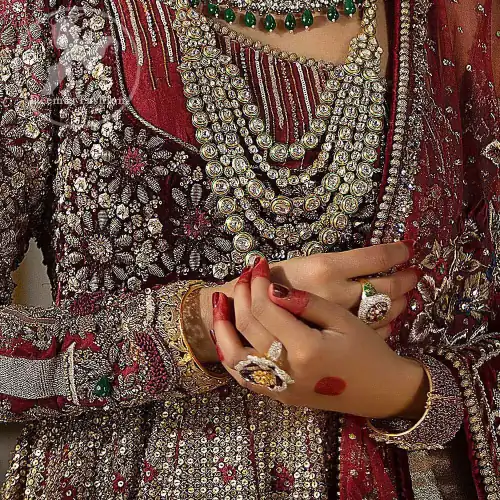 This maroon angrakha frock heavily embellished in the front with silver gold kora dabka, kundan and stones work. One side