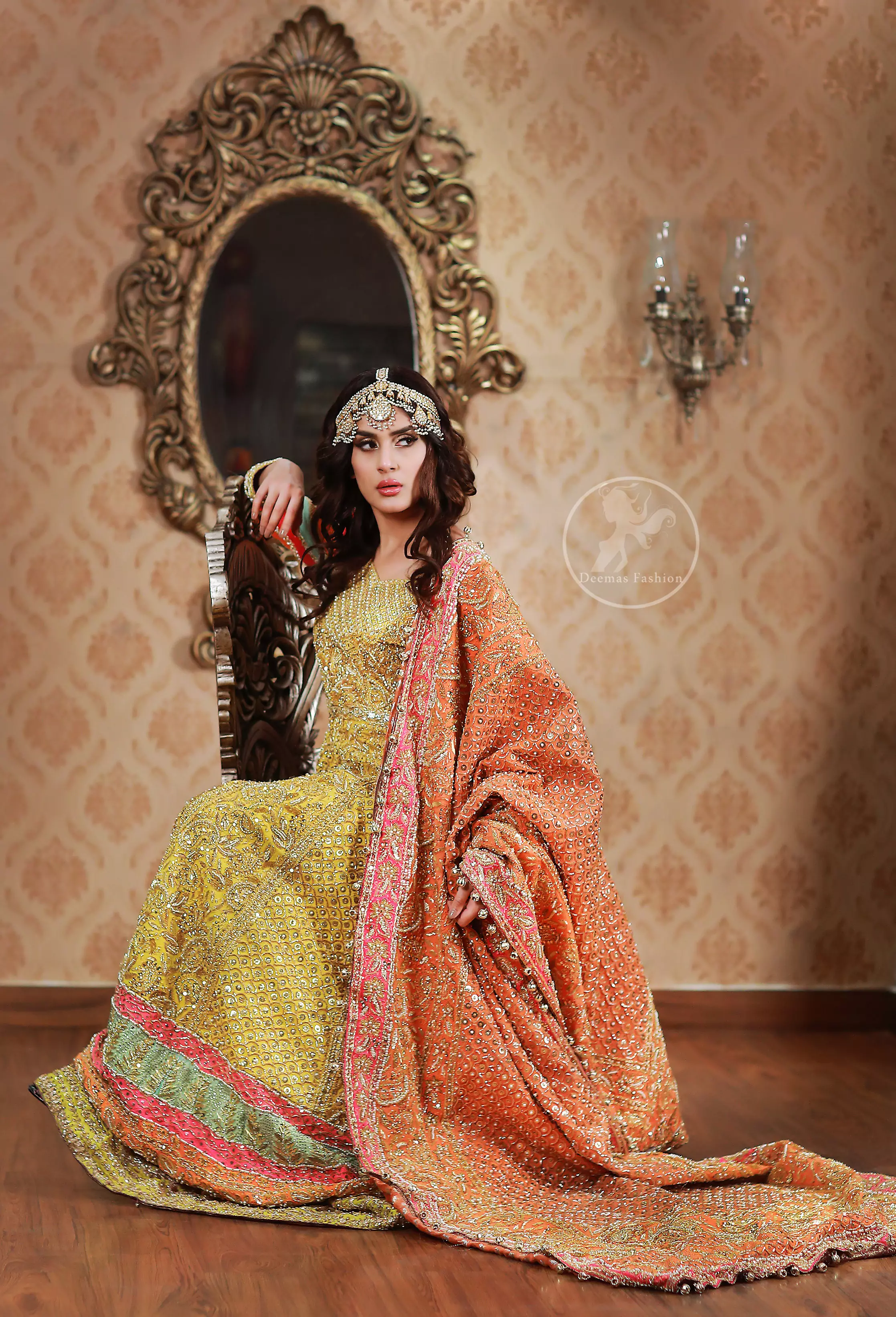 This outfit is decorated with antique shaded embroidery. The dress is fully embellished. Sleeves are decorated with different colour applique which adds to the look. It is adorned with thick embellished appliqued borders. It comes with yellow sharara and sequins spray all over it . It is coordinated with orange raw silk heavy embellished dupatta which has embellished with pink appliqued borders and beautiful tassels.