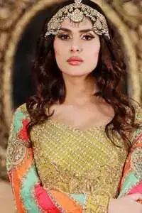 This outfit is decorated with antique shaded embroidery. The dress is fully embellished. Sleeves are decorated with different colour applique which adds to the look. It is adorned with thick embellished appliqued borders. It comes with yellow sharara and sequins spray all over it . It is coordinated with orange raw silk heavy embellished dupatta which has embellished with pink appliqued borders and beautiful tassels.