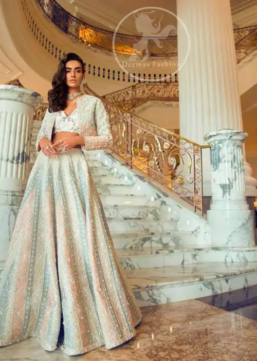 This outfit is adorned with silver and white embroidery material. Ivory jacket adorned with floral embroidery. The jacket is beautifully