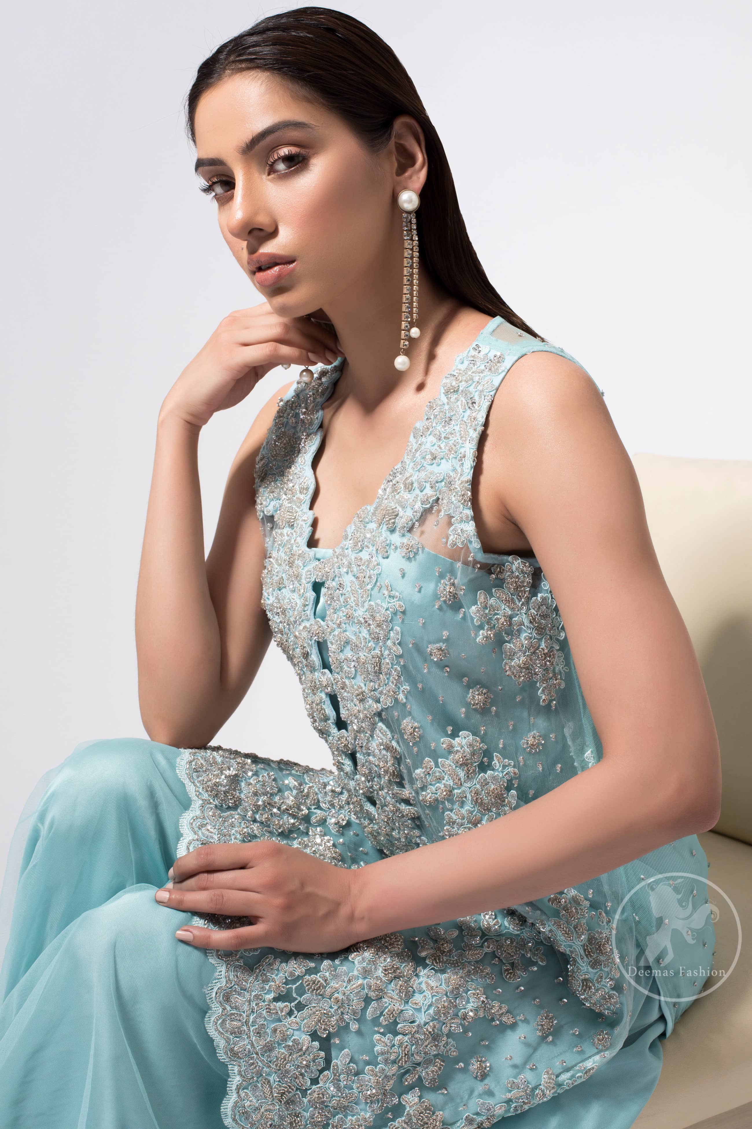 This classic shadow green shirt, meticulously highlighted with silver kora, dabka, tilla, sequins and pearls. This dress is adorned with floral motifs. Complete the look with trimming hemline embellished with heavy embroidery. It comes with shadow green organza sharara. This outfit is beautifully decorated with chiffon dupatta having sprinkled sequins all over it.
