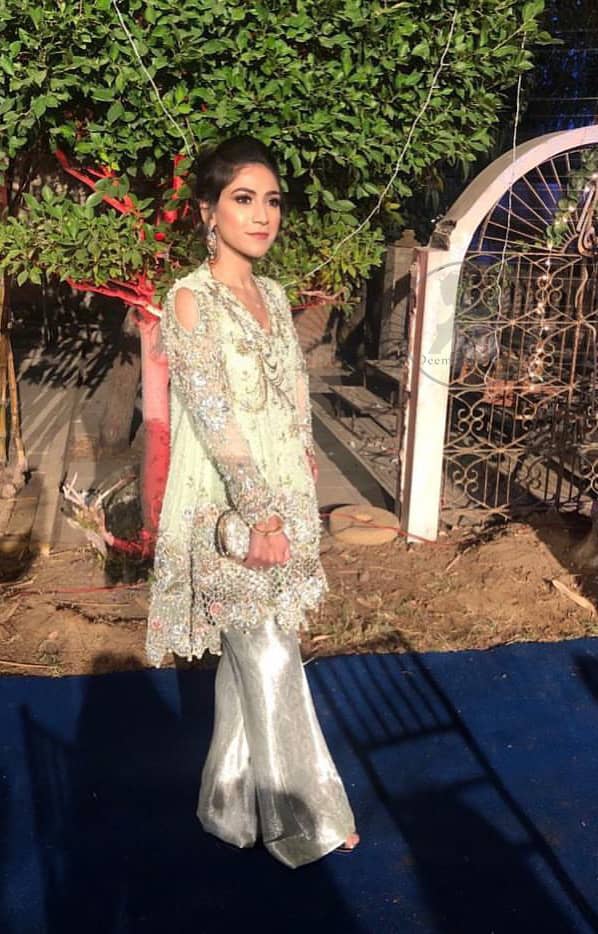 This short frok is decorated with thread, kora, dabka, tilla, sequins and swarovsky. It is embellished with floral thread embroidery. Sleeves are fully embroidered and adorned with cold shoulder design. It is decorated with intricate cutwork on hemline. It is further enhanced with embroidered scalloped border on hemline which adds to the look. It comes with brocade bell shaped pants. It is beautifully coordinated with chiffon dupatta which is sprinkled with sequins all over it.
