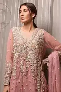 This outstanding copper rust angrakha meticulously highlighted with dull golden, tea pink and silver shaded kora, dabka , tilla, sequins and pearls. This dress is beautifully adorned with floral embroidery. It is decorated with small and large sized floral motifs. It is also embelished with beautiful tassels which adds to the look.It comes with brocade gharara pants. It is artistically coordinated with chiffon dupatta having sprinkled sequins all over it.