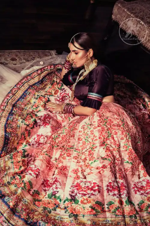 This outfit is a timeless beauty. Dark purple self-printed blouse is decorated with applique. The raw silk classic lehenga is