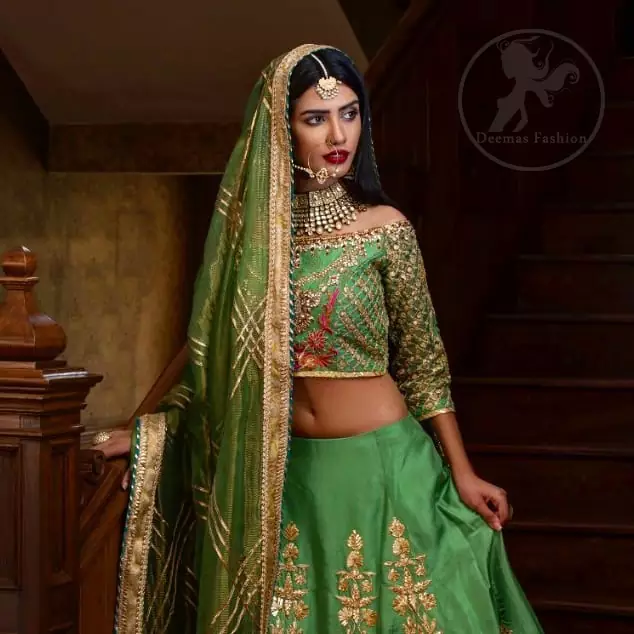 This outfit is embellished with gotta lace. It is meticulously highlighted with kora dabka, tilla, sequins and pearls. Sleeves are adorned with gotta lace in criss cross pattern. Boat-shaped neckline ornamented with floral motifs. It comes with hippie green lehenga adorned with floral embroidery. It is coordinated with chiffon dupatta embellished with applique and sprinkled sequins all over.