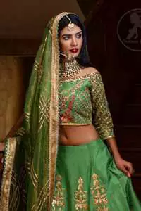 This outfit is embellished with gotta lace. It is meticulously highlighted with kora dabka, tilla, sequins and pearls. Sleeves are adorned with gotta lace in criss cross pattern. Boat-shaped neckline ornamented with floral motifs. It comes with hippie green lehenga adorned with floral embroidery. It is coordinated with chiffon dupatta embellished with applique and sprinkled sequins all over.