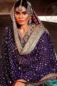 This unique bridal dress is beautifully sculptured with floral thread embroidery. It is meticulously highlighted with silver and antique kora dabka, tilla, sequins and pearls. It is artistically paired up with brocade gharara which is embellished with different color applique. It comes with chiffon dupatta which has four sided embellished border and sprinkled with sequins all over it.