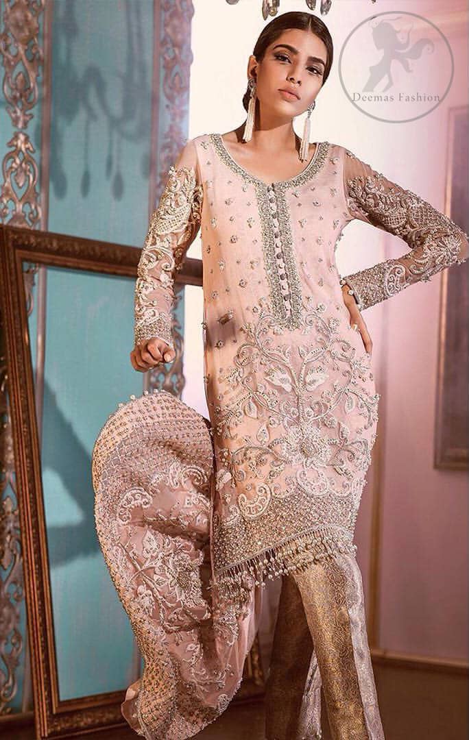 This outfit is decorated with silver kora, dabka, tilla, sequins and pearls. This dress is embellished with floral embroidery and intricate embroidered hemline. It is adorned with beautiful tassels which adds to the look. Sleeves are fully embellished. Trail is also embellished. It comes with brocade pajama. It is coordinated with chiffon dupatta which is sprinkled with sequins all over it.