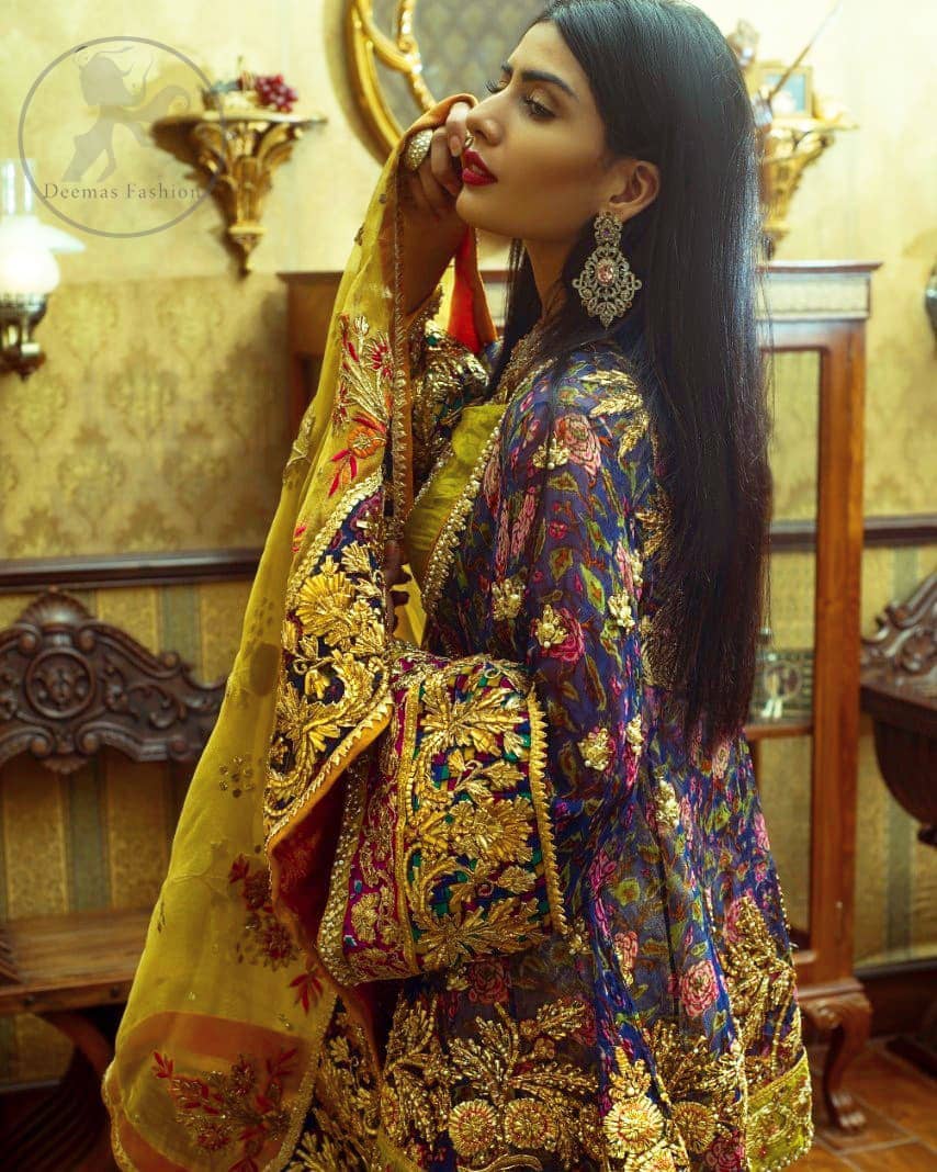 This royal blue angrakha shirt is embellished with resham thread. It is meticulously highlighted with dull golden kora dabka, tilla, sequins and pearls. Sleeves and neckline are adorned with gotta work as well. Hemline is allured with embroidered applique. It comes with embellished gharara which has sprinkled floral motifs. This Outfit is beautifully coordinated with yellow dupatta with heavy embroidered borders.