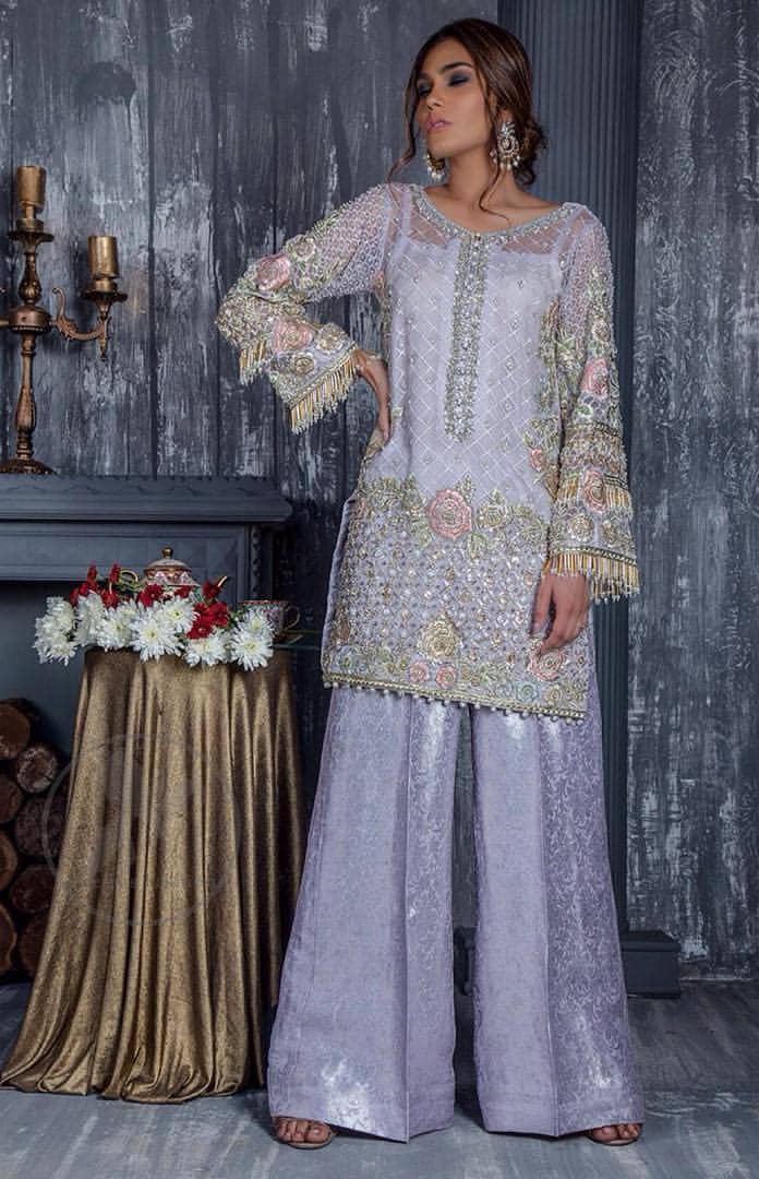 Standout in this gorgeous chiffon shirt embellished with tilla, kora dabka, sequins and pearls.It is further enhanced with floral thread embroidery.Its hemline and sleeves are beautifully decorated with golden tassels.It is beautifully coordinated with self print jacquard trousers. It comes out with chiffon dupatta decorated with sequins spray all over .