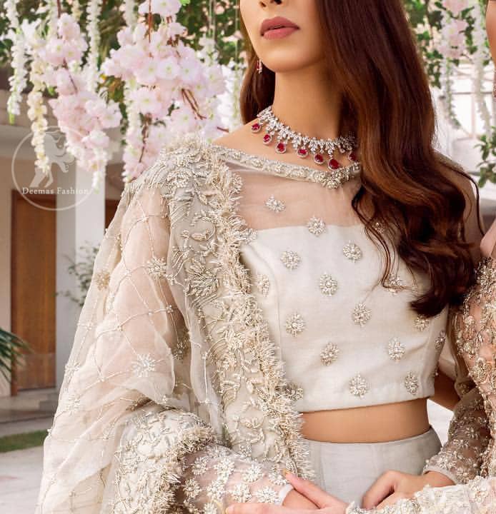 This super stunning skirt is made of rich floral embroidery which is further enhanced with kora dabka work. Blouse is meticulously embellished from neckline and sprinkled floral motifs on ground. It is paired up with ivory dupatta embellishment on sides which looks so breathtaking elaborate it with crisscross lines.