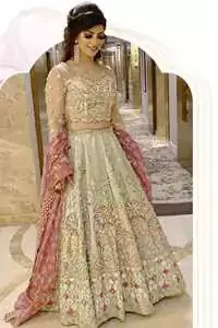 This dress is adorned with floral embroidery, highlighted with kora, dabka, tilla, sequins and pearls. It is allured with intricate embroidered motifs and detailed bodice. Blouse is scalloped. The border on hemline is enhanced with embellished floral pattern detailing, that instantly draws attention.It comes with embellished net lehengha with brocade lining. It is artistically coordinated with net dupatta which is allured with four sided border.
