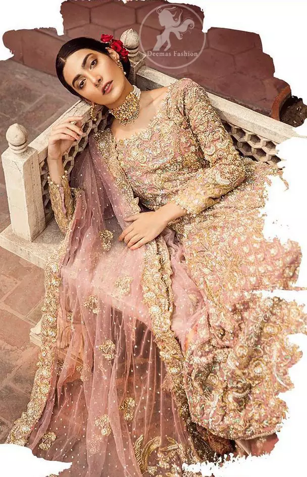 The grand gold bridal stands out due to its uniqueness and the perfect fusion of modern cut and traditional embroidery. It is highlighted with dull golden and silver kora, dabka, tilla, sequins and pearls. The frock is fully embellished from daman. It is coordinated with matching lehenga which has sprinkled floral motifs. This outfit is paired up with net dupatta which is sprinkled with sequins and small floral motifs. It is furthermore enhanced with four sided scalloped border.