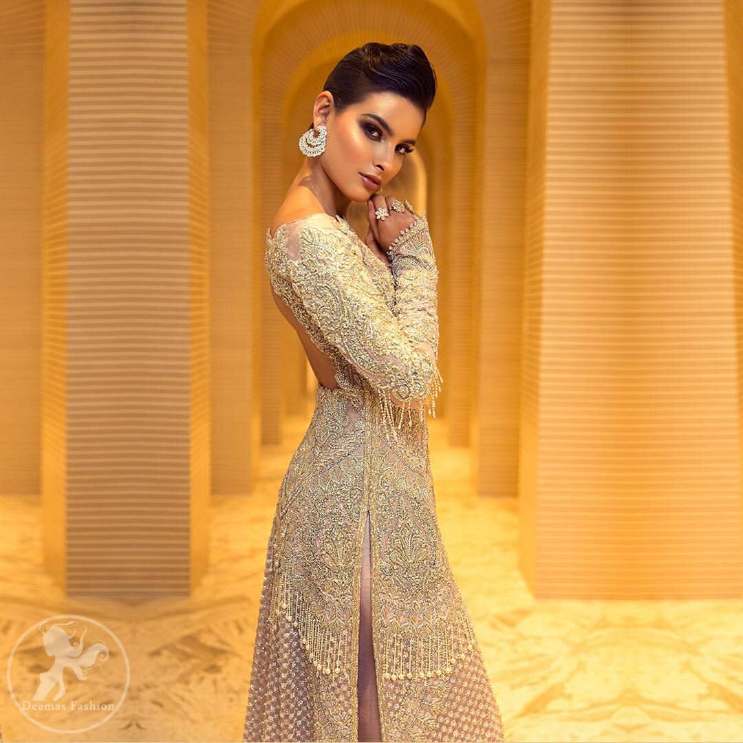This dress is beautifully decorated with heavy embroidery. It is highlighted with dull golden kora, dabka, tilla, sequins and pearls. Fish lehengha is fully embellished.Blouse is scalloped. It comes with beautifull upper gown, sprinkled with sequins all over it. It is coordinated with chiffon dupatta which is sprinkled with sequins all over it.