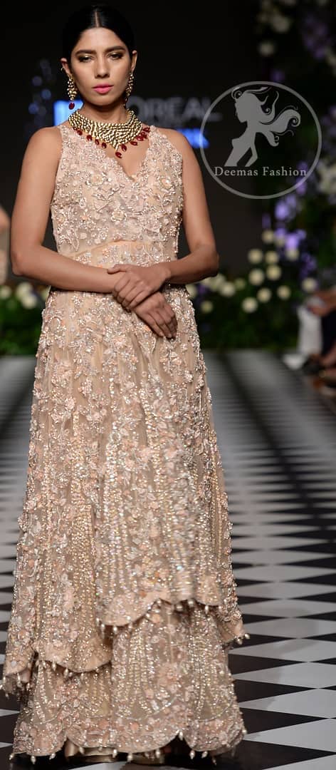 Brighten up your look with this outfit. This dress is beautifully sculptured with floral embroidery, adorned with cutwork borders embellished with dull golden kora, dabka, pearl and sequins work all over. Sharara comprises of floral thread embroidery and zardosi work adorned with thick embellished border. It is coordinated with tissue dupatta which is sprinkled with sequins all over it. It is further furnished with four sided scalloped border.