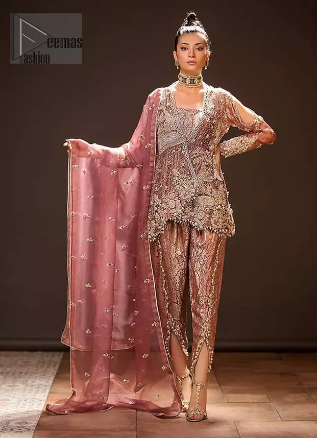 Take a step towards refreshing your wardrobe with this beautiful embroidered peplum. Beautiful embellishment created by artisans with hand done zardozi using resham, nakshi, dabki, hand cut sequins and dangling balls at the hemline. This meticulous wrap around peplum is also decorated with multiple color thread embroidery. Beautifully paired it up with copper rust tulip pants embellished with pearls. This outfit is comprises with organza dupatta with piping on all four sides and sequins spray all over.