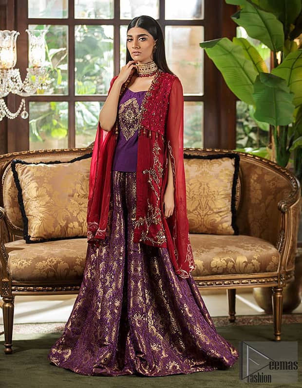 Tradition meets modernity. Boost your confidence and style in this glamorous attire accentuated with finest zardosi work, stunningly perfect for any evening ensemle. Short shirt is ornamented with a large motif in the center done with antique shaded kora, dabka, tilla and sequins. Pair it up with deep red gown beautifully adorned with floral thread embroidery on the bodice and finishing with tassels. Furthermore it is highlighted with floral bootis. Finish the look with brocade sharara. It is comprises with golden brocade dupatta having embellished red applique on all four sides.
