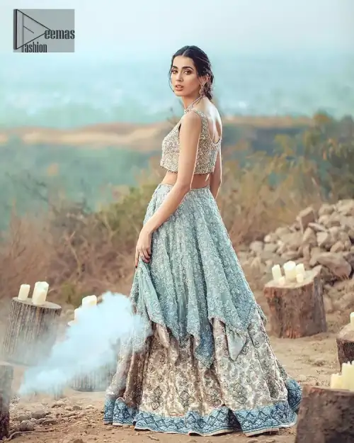 This bridal dress executing heavily hand crafted art of zardosi, kora and dabka with splashes of golden and silver is