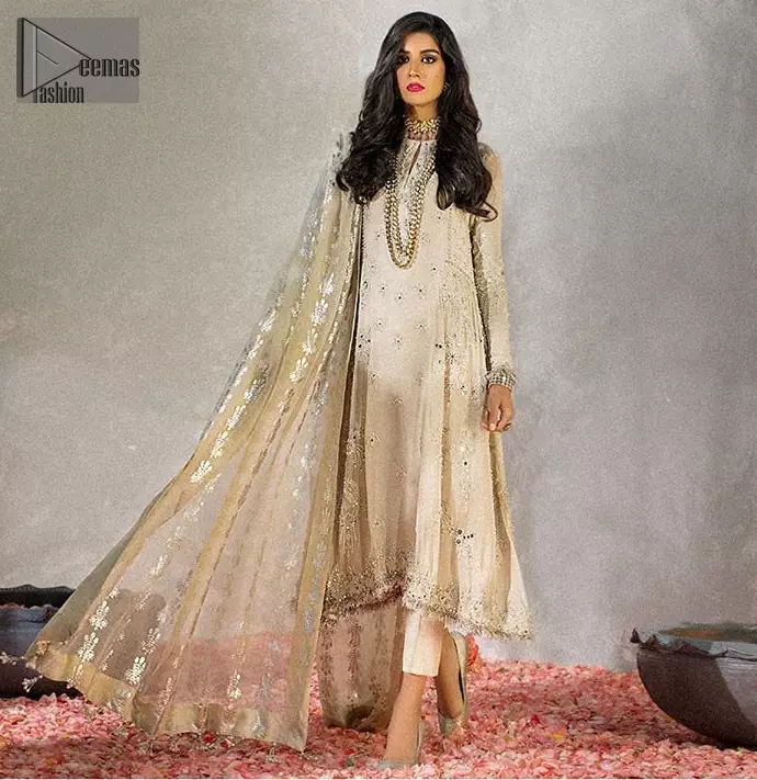 Reflecting royalty and the majestic beauty of statuesque shape and silhouette which makes the dress perfect for nikah day. This regal ivory a-line shirt is an immensely captivating traditional piece. Having full length sleeves adorned with a large floral motif in the center. The daman is furthermore highlighted with matching embellishment that instantly draws attention. It comprises with cigarette pants. Pair it up with self embroidered tissue dupatta.