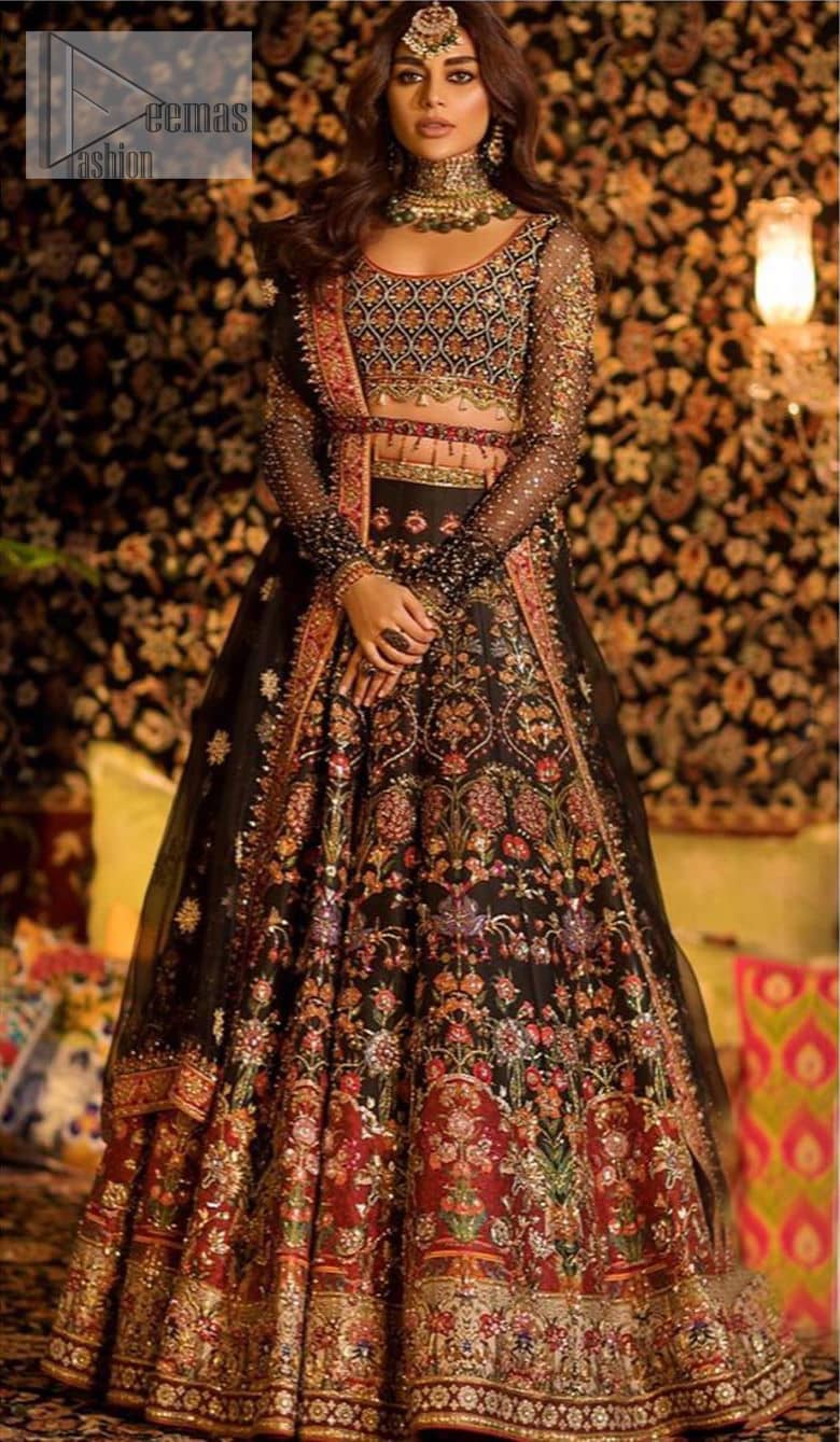 Tradition meets modernity. Go glam in our black traditional lehenga blouse. This outfit bursts of vibrant colors and sumptuous details of zardozi, gota, kora and dabka is a perfect Mehndi ensemble. It is aesthetically designed with thick borders and floral bunches refined the classical royal look. Blouse is decorated with geometric patterns having full sleeves adorned with zardosi work and sprinkled sequins. Style it up with black net dupatta sprinkled with tiny floral motifs and four sided applique embellishment. The piece comes with a handcrafted belt.