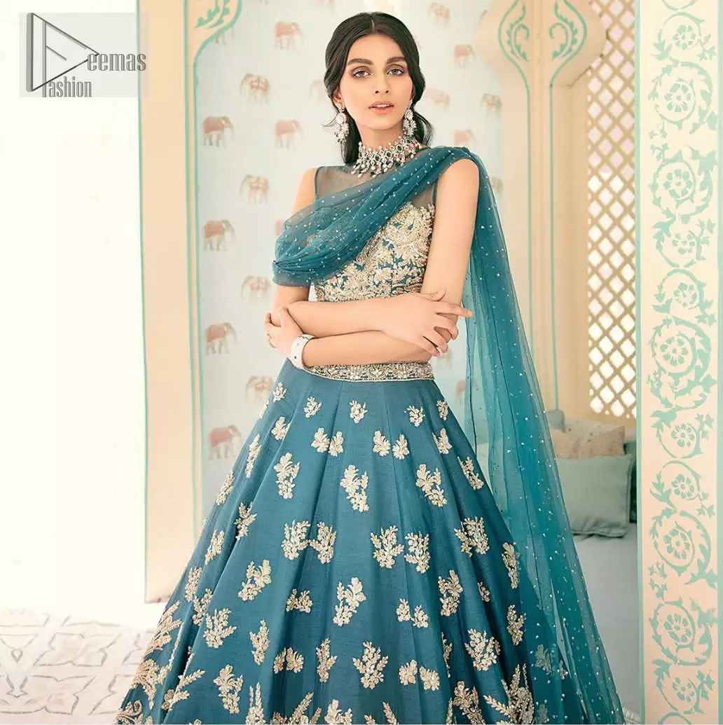 Captured in traditional silhouette. The bridal stands out due to its uniqueness and the perfect fusion of modern cut and traditional embroidery. It is highlighted with light golden kora, dabka, tilla, sequins and pearls. Blouse is enhanced with zardosi work. It comes with full embellished lehenga adorned with different size motifs and floral bunches. Style it up with net dupatta which is sprinkled with sequins all over it and embellished pallu to give it a perfect look.