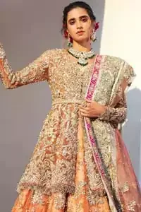 Captured in traditional silhouette, The bridal stands out due to its uniqueness and the perfect fusion of modern cut and traditional embroidery. This front open short frock is highlighted with kora, dabka, tilla, sequins and pearls. It comes with full embellished lehenga adorned with floral bunches, applique on the hemline and sequins spray all over it. It is coordinated with organza dupatta which is sprinkled with tiny floral motifs all over and a thick embellished border on all four sides with applique details.