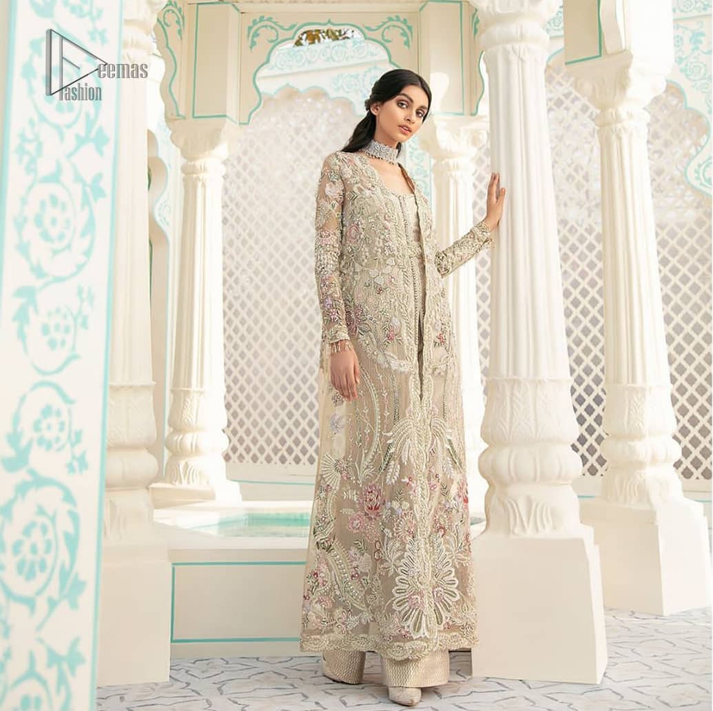 An example of beauty and elegance. A perfect ensemble for this festive season with divine detailing of thread embroidery, color balance and well-crafted scalloped bottom. The front open gown is sculptured with light golden zardozi work all over and multiple color thread embroidered floral. Complete the look with inner jumpsuit style it up with a fixed waist belt. Paired it up with organza dupatta adorned with scattered floral motifs.