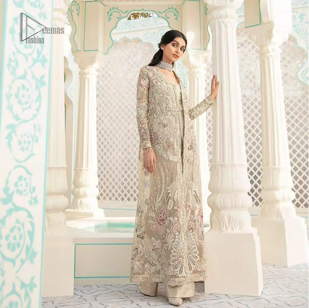 An example of beauty and elegance. A perfect ensemble for this festive season with divine detailing of thread embroidery, color balance and well-crafted scalloped bottom. The front open gown is sculptured with light golden zardozi work all over and multiple color thread embroidered floral. Complete the look with inner jumpsuit style it up with a fixed waist belt. Paired it up with organza dupatta adorned with scattered floral motifs.