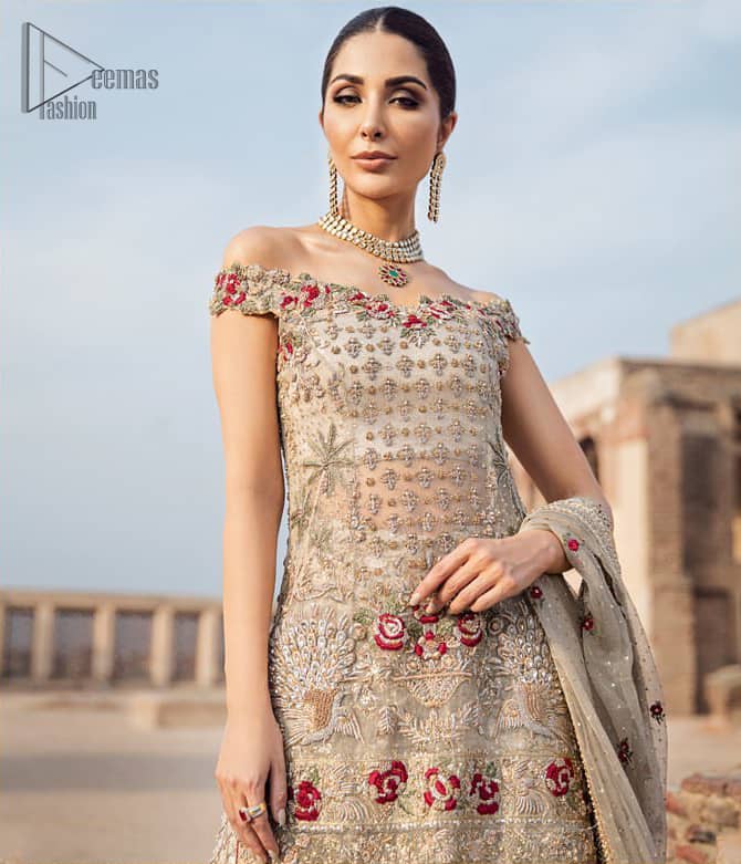Classic and elegant, this dress is perfect for brides looking for a traditionally wedding outfit.. A perfectly pretty combination of light golden and antique embellishment, This off shoulder wedding dress is elegant and eye-catching in equal measure. This off shoulder shirt is done with zarozi detailing and vibrant floral motifs all over. Furthermore it is sculptured with different motifs like birds. It comprises with traditional handcrafted gharara. Complete the look with off white organza dupatta having four sided heavily embellished border and tassels.