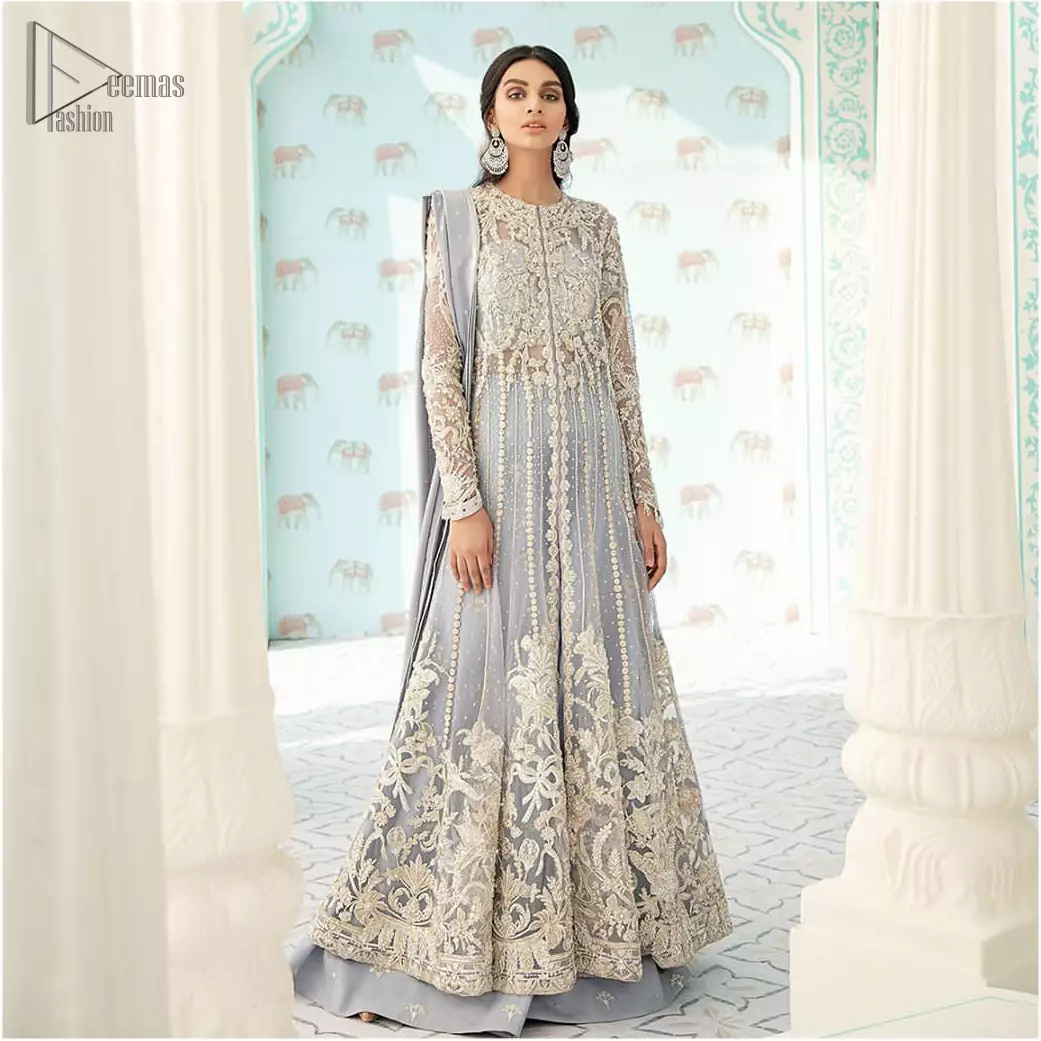 You are all set to make a lasting impact with the divine royalty of this dress. This artisan piece includes intricate hand-embellishment. This technique gives this garments a unique look, and helps to sustain a traditional craft carried out by skilled artisans. This multiple panels front open maxi is ornamented by light gold zardozi work with beautiful embellished motifs around the hem and vertically worked gold lines. It comprises with raw silk sharara adorned with tiny floral motifs and dupatta is decorated with sequins spray all over.