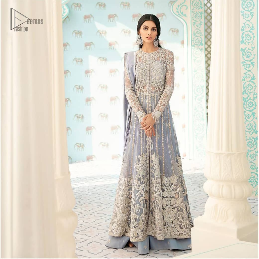 You are all set to make a lasting impact with the divine royalty of this dress. This artisan piece includes intricate hand-embellishment. This technique gives this garments a unique look, and helps to sustain a traditional craft carried out by skilled artisans. This multiple panels front open maxi is ornamented by light gold zardozi work with beautiful embellished motifs around the hem and vertically worked gold lines. It comprises with raw silk sharara adorned with tiny floral motifs and dupatta is decorated with sequins spray all over.