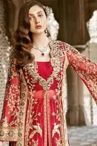 Beautifully elegant with a modern twist. This dress is crafted from delicate floral lace and features a scalloped plunge neckline. The front of the gown is adorned with floral embroidery, bunches and thick embellished side slits done with golden and antique zardozi work. Back of the gown is emphasized with black applique detailing and geometric patterns. The gown is finishing with tassels on the hemline on both sides frond and back. The palazzo pants is adorned with thick embellished applique bottom with golden kora, dabka, tilla and sequins embroidery. It comprises with red chiffon dupatta with sequins spray all over.
