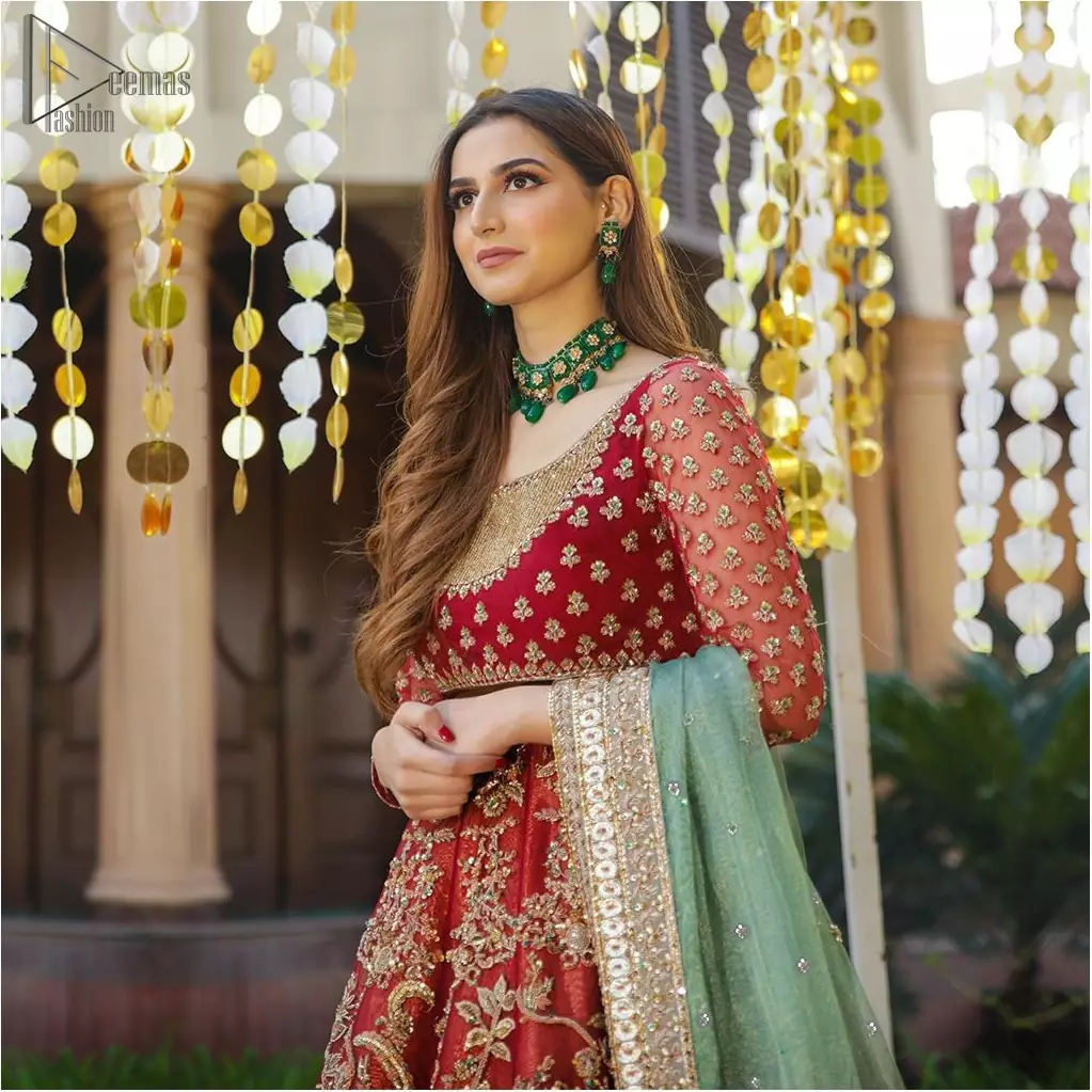 Make a special day even more magic with our exquisite bridal dress. This wedding dress is elegant and eye-catching in equal measure. Strike a breathtakingly elegant pose in this wedding dress, designed with a beautiful neckline embellished with sequins details and scattered tiny floral motifs all over. The lehenga is decorated with floral embroidery all over and finished with frilled fabric. The mint green organza dupatta with chann and finishing all around the edges makes the look complete.