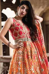 This artisanal piece is rendered in grace and timelessness. Brighten up your look with this mix of floral and geometrical embroidery in vibrant tones spread across on red and orange canvas. The front open pishwas is delicately crafted with zardozi work, multiple color embroidery and mirror work. Furthermore it is also adorned with green embellished applique and the colorful applique lift the whole bottom. It comprises with orange sharara. Finished the dress with red and orange organza dupatta with geometric patterns on the ground.