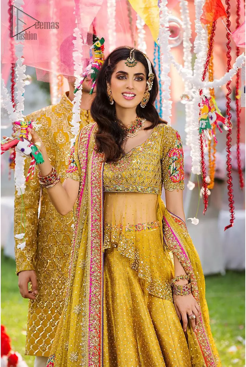 The perfect choice for Mahendi. Delicately crafted and personifying chic elegance with an element of grandiose. The shirt is emphasized with traditional neckline and a small back train. And the lehenga is decorated with intricate floral daaman enhanced with multiple color thread embroidery and rich zardozi work. Paired it up with yellow net dupatta sprinkled with sequins on the ground and four sided applique border.