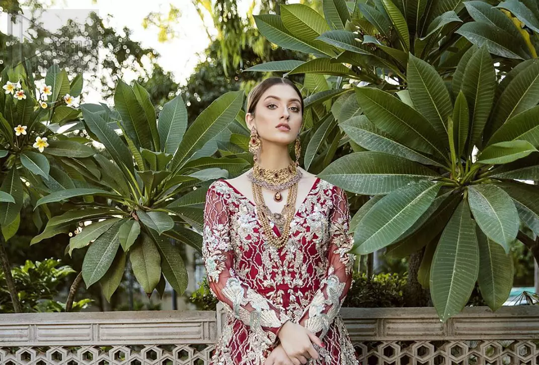 This front open marron maxi is creating a dreamy composition. The chic yet elegant front open maxi is decorated with floral embroidery , heavily embellished bodice and floral bunches. Hemline is even more enhanced with birds motifs finished with jamawar lining adorned with geometric patterns in it. The embroidery is done with silver and white kora, dabka, tilla, and pearls. It comes with straight trousers allured with sprinkled motifs on dupatta dupatta finished with silver lace all around the edges.  