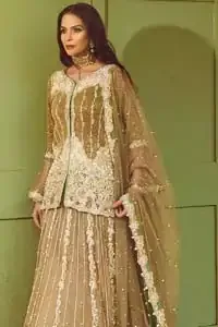 Let the crowd stare and make it worth their while when you walk wearing this outfit. Designed to flaunt your best features, the front open shirt carries intricate embellishment on the hemline and neckline. Complete the look with artfully coordinated lehenga which is ornamented with a bold and captivating design with a traditional intricate embroidery. Furthermore the lehenga and shirt is also emphasized with silver embroidered vertical lines. The fawn net dupatta with chann and scalloped finishing all around the edges makes the look complete. Upholding the idea of simple is beautiful, you would definitely want to wear this for your next occasion.