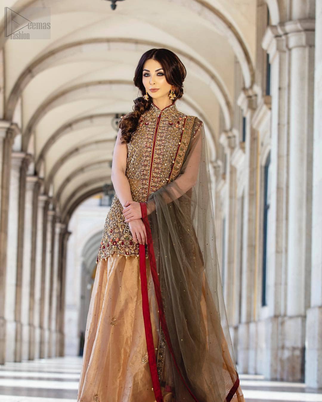 Our selection of wedding dresses offers simple evening glamour dresses. Add a taupe gray color to your wardrobe with our modern styled front open shirt enhanced with embellished geometric patterns. The neckline is beautifully designed with collar neck and scalloped hemline is emphasized with dangling pearls and multiple color embroidery. It is paired with taupe gray dupatta with one sided hand embellished border and sprinkled sequins all over. Compliment the look with fawn lehenga adorned with floral bunches. The combination of fawn and taupe gray is absolutely breathetaking.