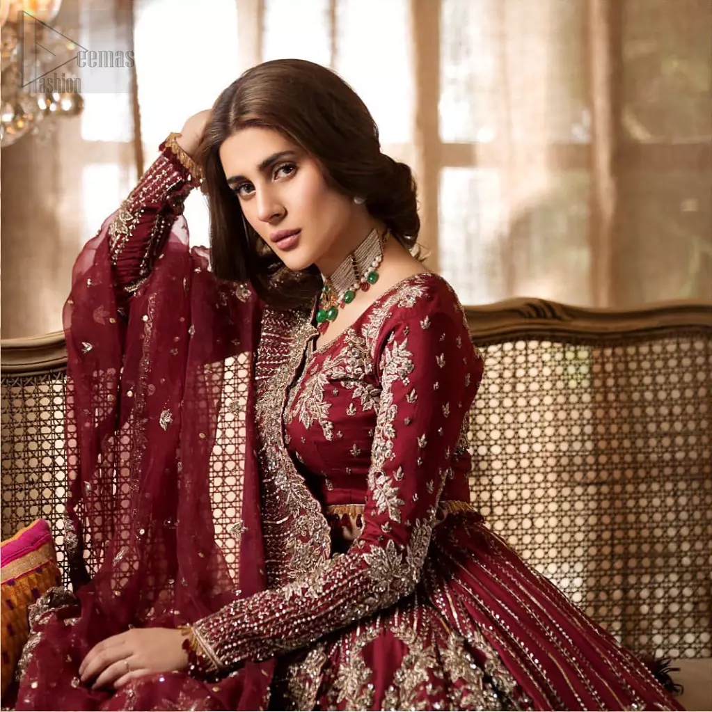 Make your big day more beautiful with our excessively embroidered lehenga blouse featuring delicately embellished back train along with scalloped finishing highlighted with antique embroidered detailing and intricately frilled inner that gives perfect ending to this outfit. The blouse is delicately crafted with antique zardosi work having full sleeves with dangling finishing. It is paired with an ethereal bridal dupatta focusing on kora and dabka handwork borders on all four sides, finished with scalloped borders. With a flowing trail, this is an ensemble that deserves to be flaunted.