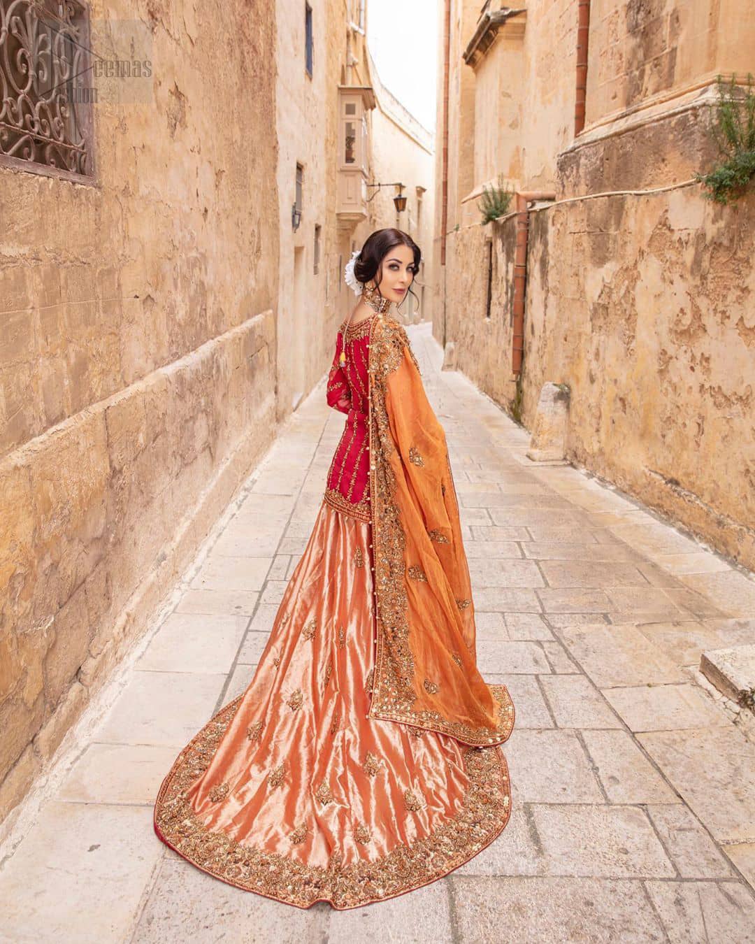 Make your big day more beautiful with our excessively embroidered back train lehenga shirt featuring delicately embellished neckline along with geometric patterns highlighted in antique shaded embroidery detailing and intricately embroidered borders that gives perfect ending to this outfit. Pair it up with a breathtaking back train lehenga with scattered motifs on the ground and embellished hemline. The orange organza dupatta with floral motifs and finishing all around the edges makes the look complete. The combination of orange with red is absolutely breathetaking.