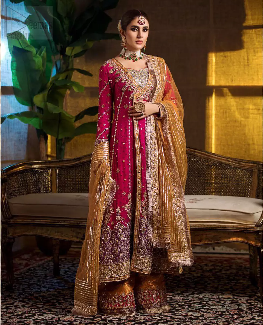 Impeccably on trend. The chic yet elegant front open angrakha style frock is decorated with vertical embroidered lines, embellished neckline and floral bunches. Borders are even more enhanced with rust applique details done with golden and light golden zardozi work. It comes with brocade rust sharara exaggerated with embroidered pink applique on the bottom. Elegance is personified when it gets paired up with rust dupatta decorated with four sided kiran lace and zardozi work on all four sides.
