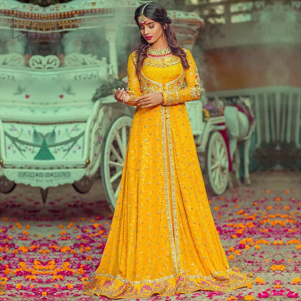 Adorn yourself with this breath-taking mehndi outfit. Be it the next mehndi right after a family festivity. A delicate arrangement of hand embellished tiny floral motifs on the ground and heavily embellished from bodice and neckline with golden and pink zardozi work. The daaman is emphasized with intricate zardozi details and multiple color thread work that gives perfect ending to this outfit. Pair it up with yellow churidar pajama. To complete the look, go with yellow chiffon dupatta scattered with tiny floral motifs and kiran on all four sides.