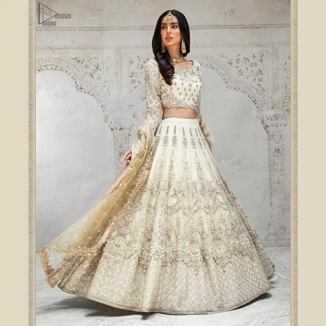 Designed with great expertise, the Ivory Blouse Lehenga is going to set you on a heavenly journey, full of comfort, merriment and unlimited beauty. In a professional sense of full sleeves, the dress is laudable for its majestic light golden and silver embroidery under the very meritorious round neckline. To contribute towards its eminence, this bridal wear is made with the finest organza. A lehenga and an exquisite net dupatta make this marvelous attire a paragon of extreme beauty on your Walima.