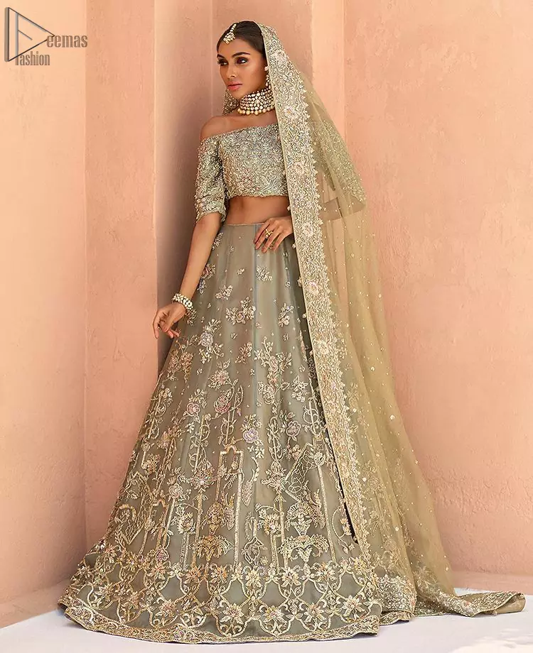 When extreme beauty is your identity, the Olive Green Off Shoulder Blouse Lehenga makes sure it boosts your gorgeousness with its much more attractive elegance. This paragon of exquisiteness is designed with three-quarter sleeves, making sure it meticulously matches its objective. The silver and golden embroidery serve as the cherry on top, while the stunning floral motifs do not fail to catch all admiring eyes on the finest details of adornment on the dress. Finest organza as always is the prime choice for an attire so meritorious and the concluding marvellous net dupatta prepares this laudable dress to brighten up your Walima ceremony.