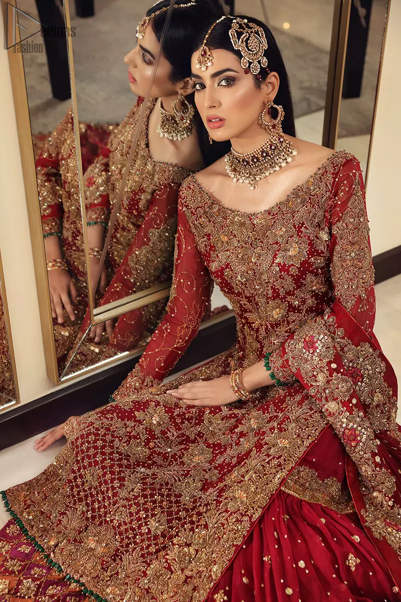 Maroon bridal wear long shirt, appliqued Gharara and matching heavily embroidered dupatta. We will make you believe in fairy-tales! Ethereal handcrafted luxe ensemble, fit for a princess glammed out with gorgeous layers of hand-embroidered details, timeless silhouette and dreamy embellishment. The outfit is finished with beautiful maroon organza gharara having appliqued embroidery below the gott. This colourful gharara having thick embroidery borders gives it a regal look.